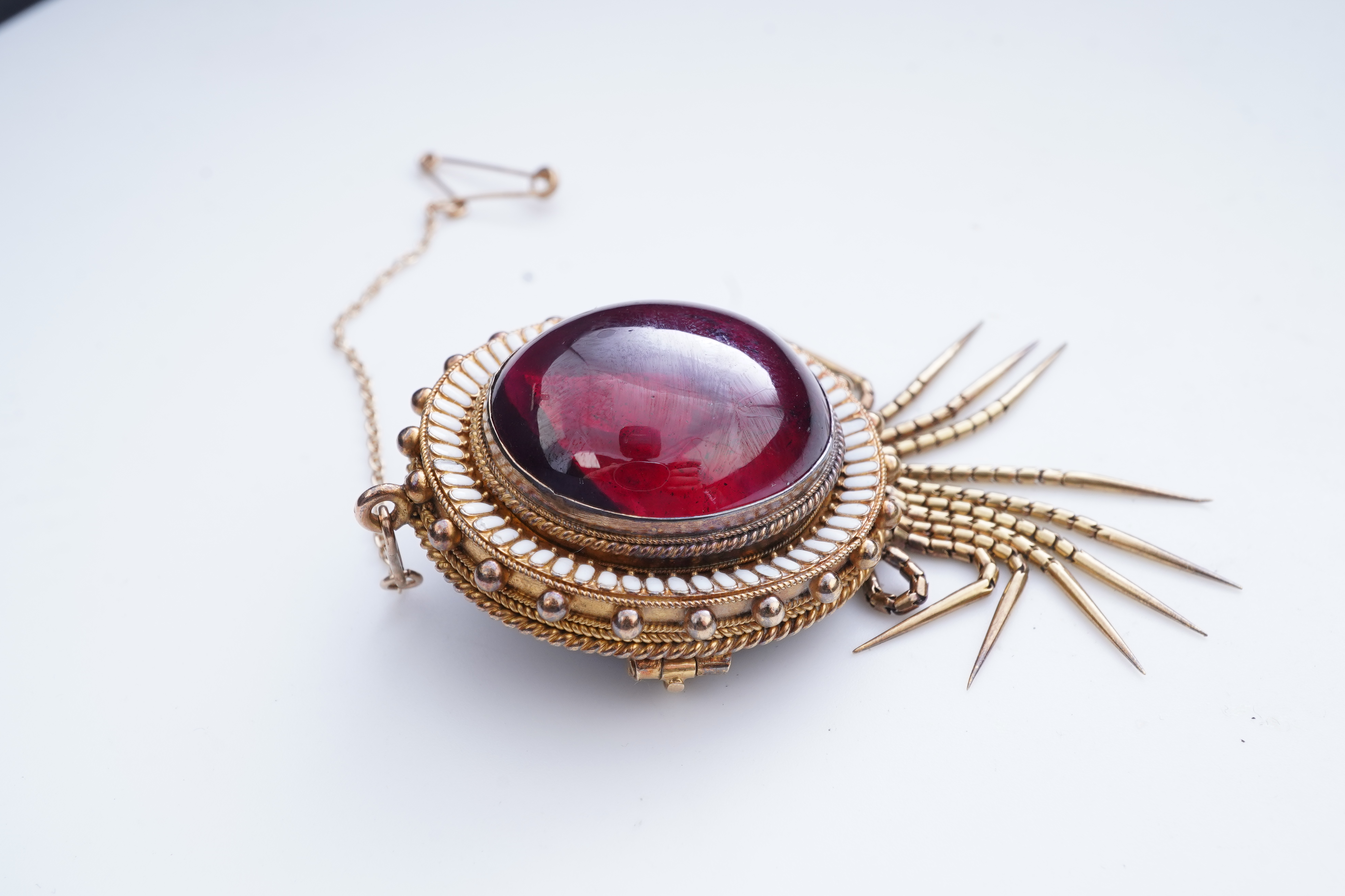 A Victorian garnet and enamel brooch, mid 19th century
